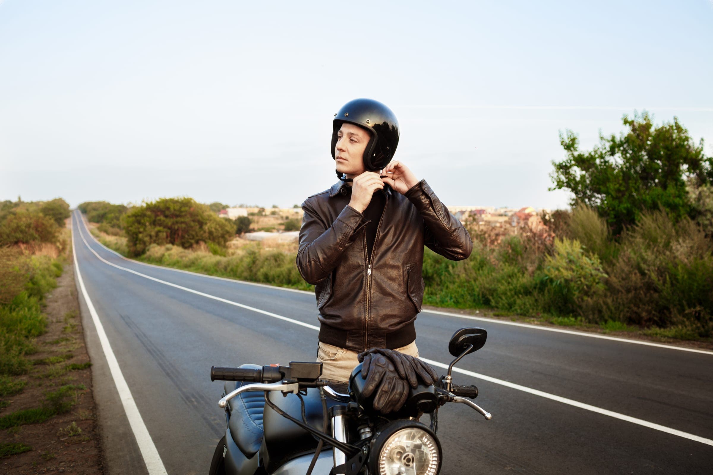 A rider fastening the chin strap of his helmet before setting off